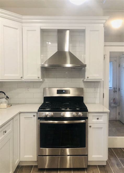 antique white cabinets with stainless steel hood over stve|antique white cabinet ideas.